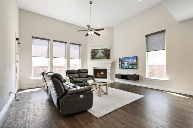 a living room with furniture a fireplace and a large window