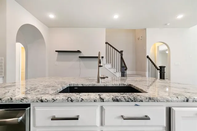 a kitchen with stainless steel appliances granite countertop a sink stove and cabinets
