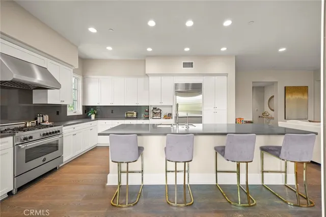 a large kitchen with kitchen island a sink table and chairs