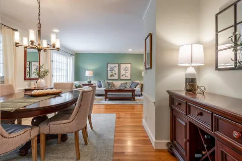 a view of a a dining room with furniture window and wooden floor