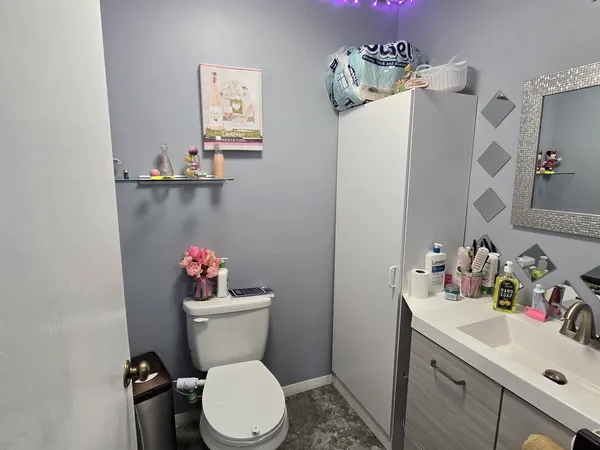 a bathroom with a sink mirror vanity and toilet