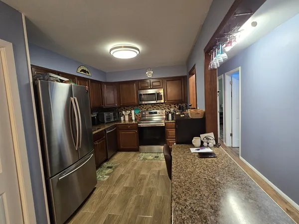 a kitchen with a refrigerator a microwave and cabinets