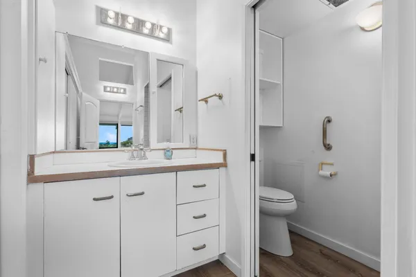 a bathroom with a granite countertop sink a toilet and a mirror