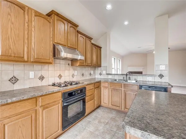 a kitchen with stainless steel appliances granite countertop a sink stove and cabinets