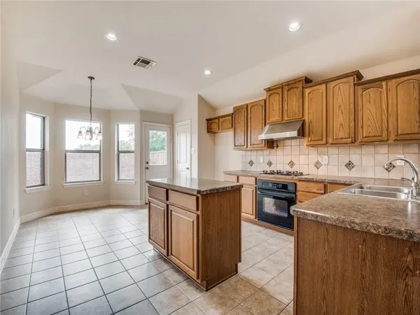 a kitchen with stainless steel appliances granite countertop a stove top oven a sink a counter top space and cabinets