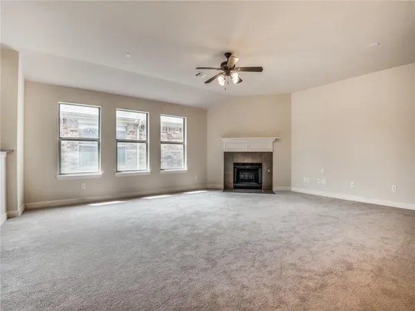 an empty room with windows and fireplace