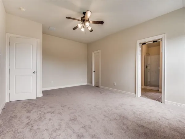 a view of an empty room with a chandelier fan