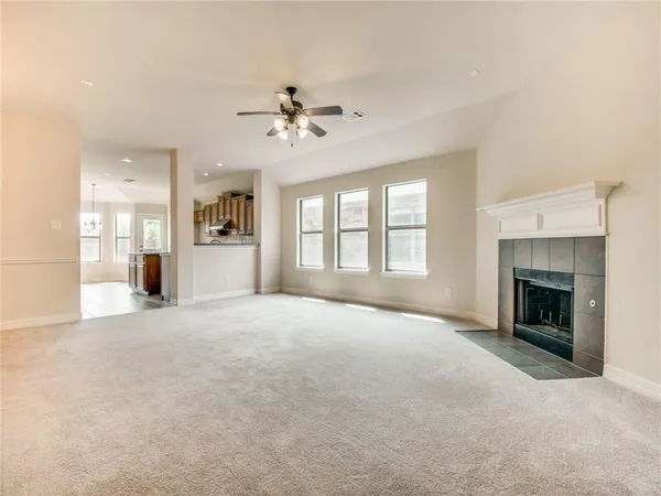 a view of an empty room with a fireplace and a window