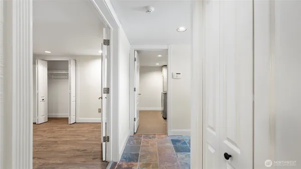 a view of a hallway with wooden floor and staircase