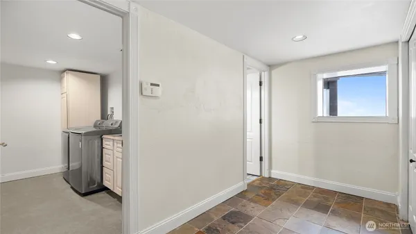 a view of an empty room with closet and a window