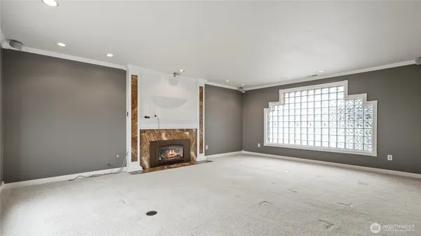 a view of an empty room with a fireplace and a window