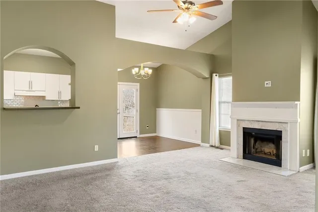 an empty room with windows and fireplace