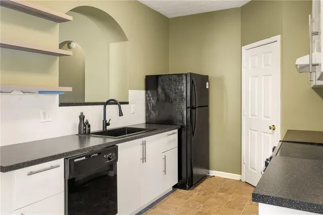 a kitchen with stainless steel appliances granite countertop a refrigerator and a sink