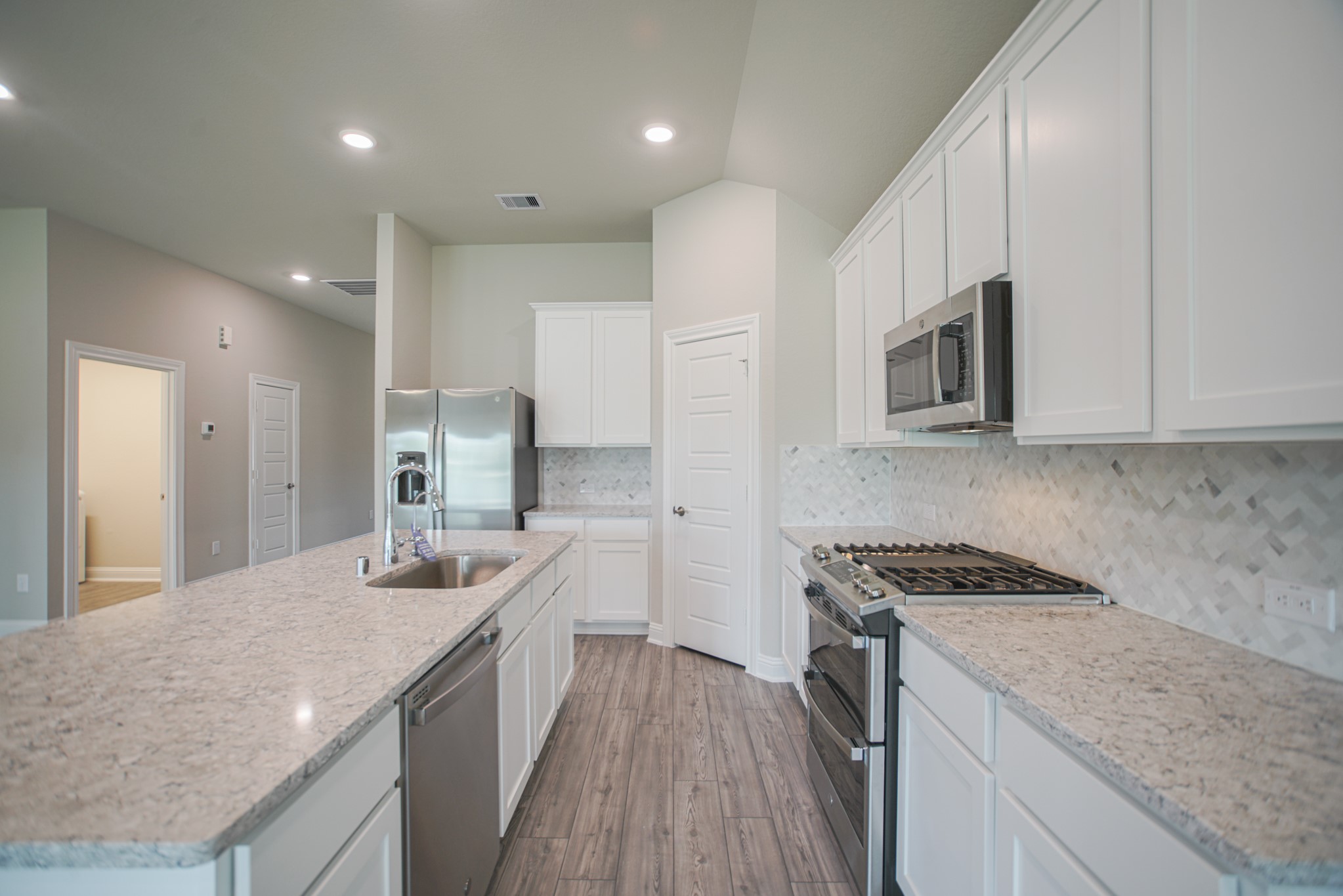 17112 Coneflower Place Conroe, TX 77385 - Photo 11 of 27 a kitchen with a sink stove and cabinets
