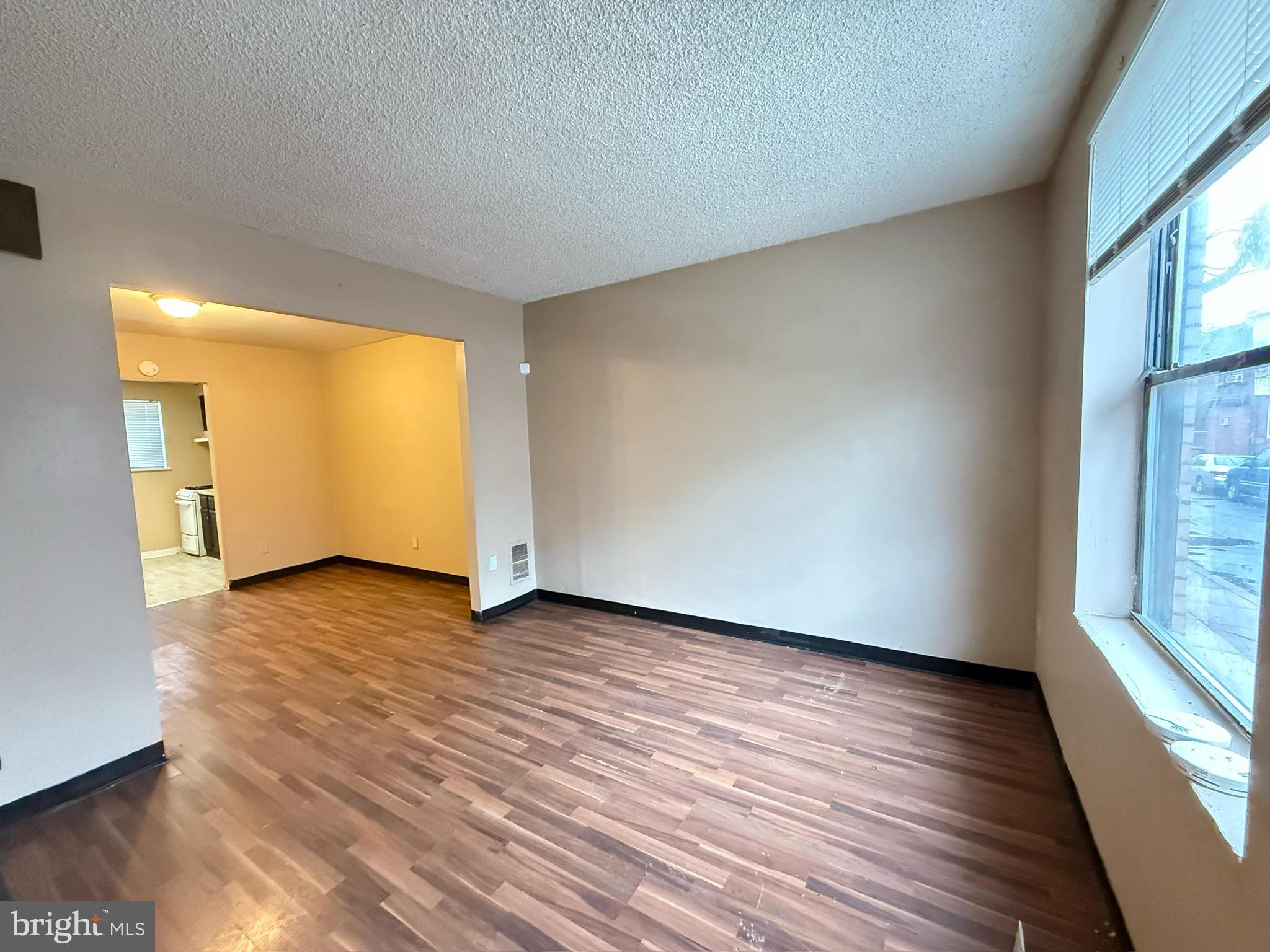 2219 Winton Street Philadelphia, PA 19145 - Photo 3 of 8 a view of an empty room with wooden floor and a window