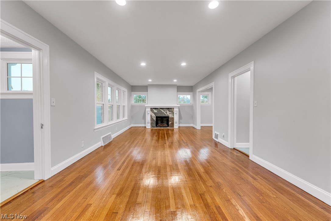 Unfurnished living room featuring a fireplace and light hardwood floors