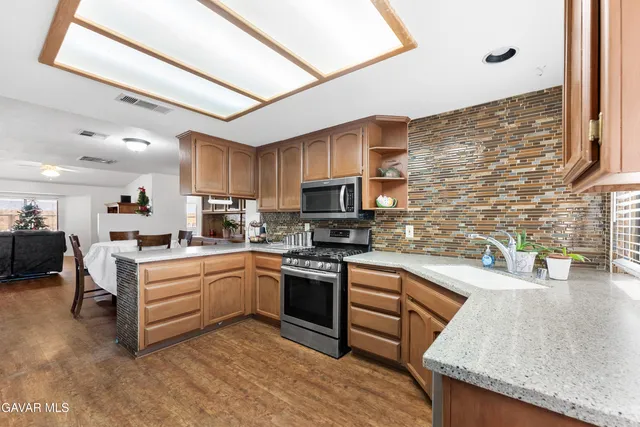 a kitchen with stainless steel appliances granite countertop a stove sink and cabinets