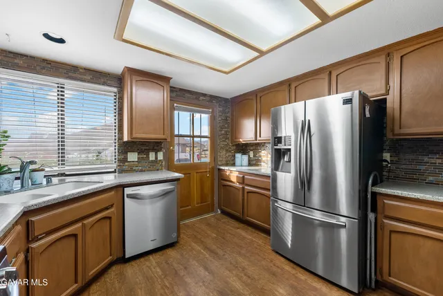 a kitchen with stainless steel appliances a refrigerator sink and microwave