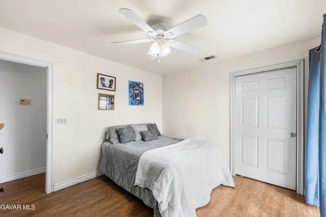 a bedroom with a large bed and a ceiling fan