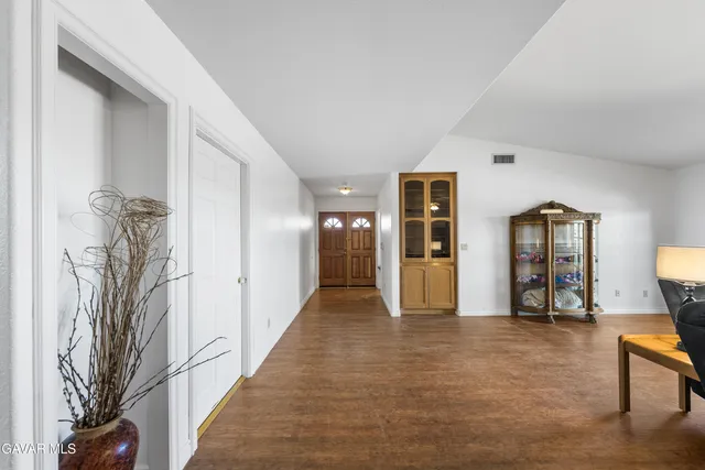 a view of a hallway with wooden floor and furniture