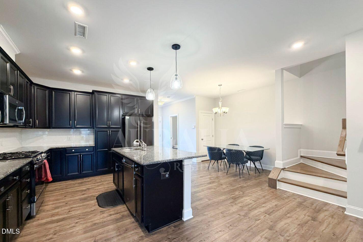1306 Farm Pond Trail Durham, NC 27703 - Photo 13 of 46 a kitchen with stainless steel appliances granite countertop a table chairs sink and cabinets
