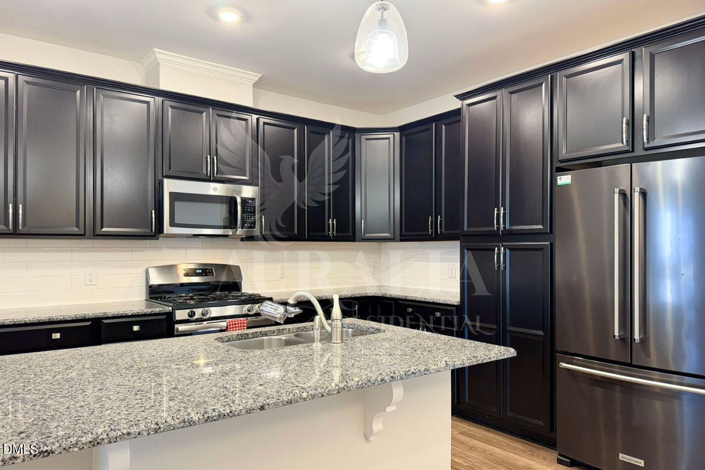 1306 Farm Pond Trail Durham, NC 27703 - Photo 8 of 46 a kitchen with stainless steel appliances granite countertop a refrigerator a stove and a sink with wooden cabinets