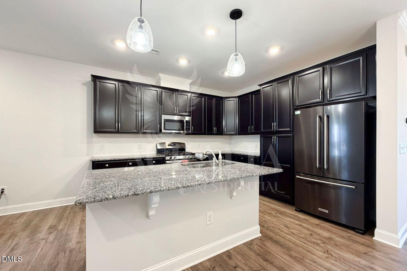 1306 Farm Pond Trail Durham, NC 27703 - Photo 10 of 46 a kitchen with stainless steel appliances granite countertop a refrigerator a sink dishwasher a stove and a refrigerator with wooden floor