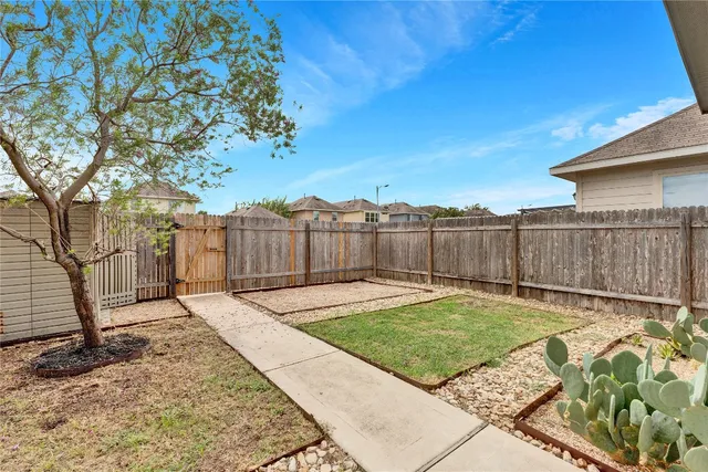 a view of a backyard with wooden fence