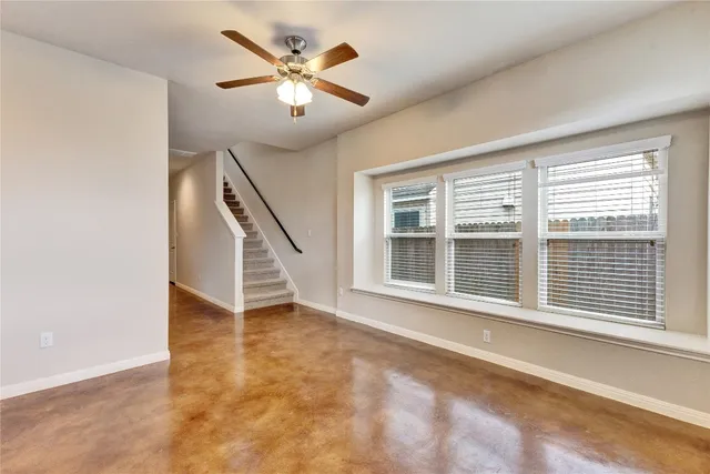 a view of an empty room with a window and a ceiling fan
