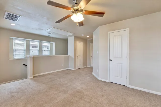 an empty room with fan and windows