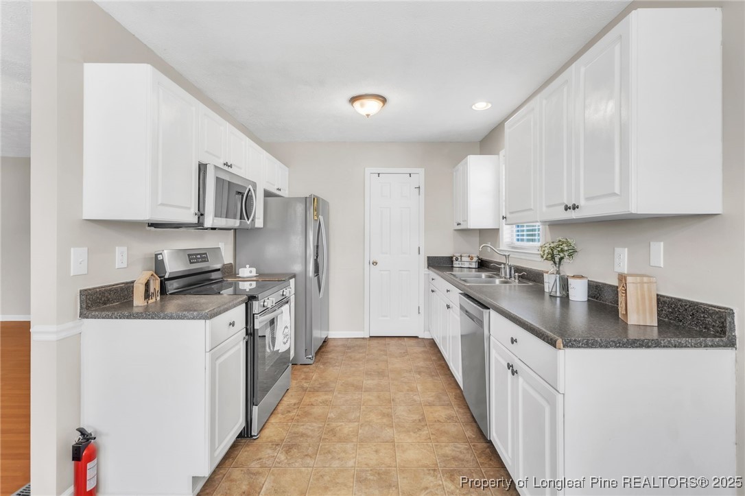 45 Ridgecrest Road Cameron, NC 28326 - Photo 11 of 32 a kitchen with stainless steel appliances granite countertop a stove a sink a refrigerator and cabinets