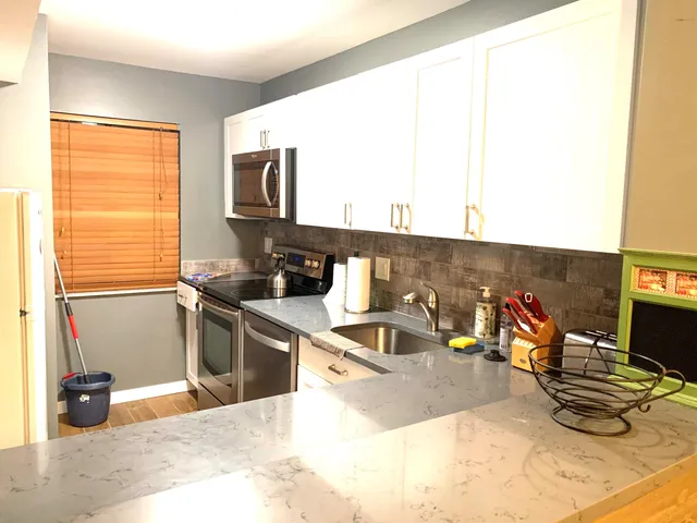 a kitchen with stainless steel appliances granite countertop a sink and a stove