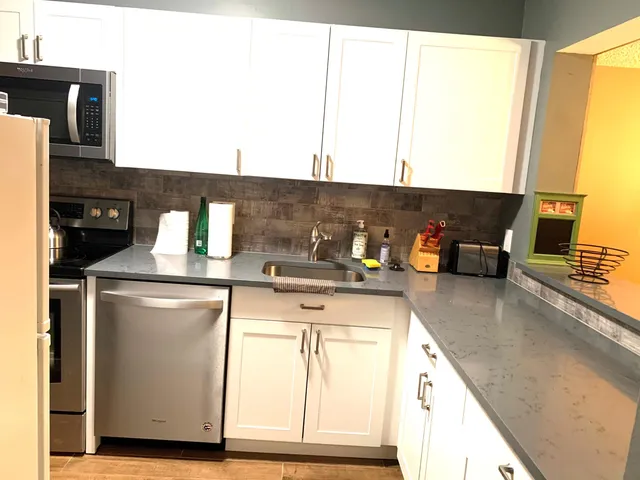 a kitchen with a sink and a stove next to a window