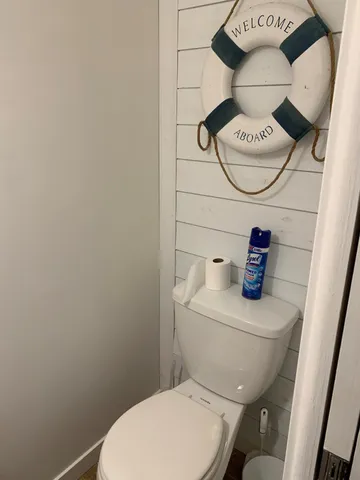 a white toilet sitting next to a bathroom sink and vanity