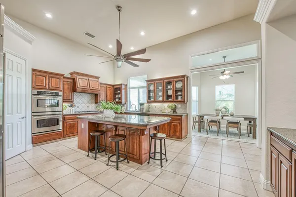 a kitchen with stainless steel appliances granite countertop a sink a stove and a wooden cabinets