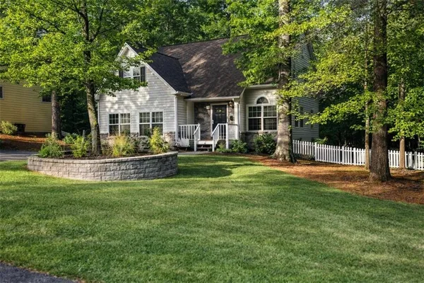 a view of a house with a big yard plants and large trees