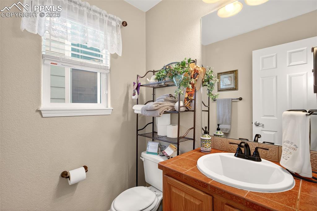 7374 Maybeck View Peyton, CO 80831 - Photo 12 of 38 a bathroom with a sink a toilet and mirror