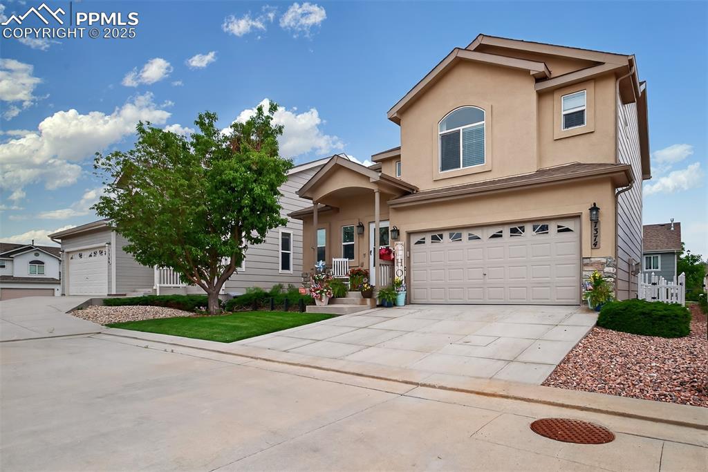 7374 Maybeck View Peyton, CO 80831 - Photo 2 of 38 a front view of a house with a garden and a garage