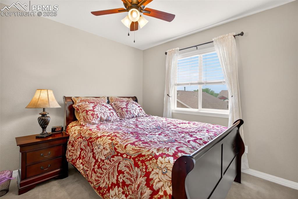 7374 Maybeck View Peyton, CO 80831 - Photo 23 of 38 a bedroom with a bed and a lamp