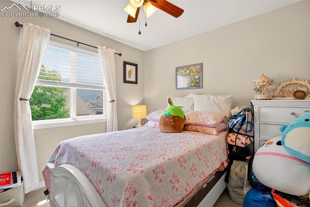 7374 Maybeck View Peyton, CO 80831 - Photo 26 of 38 a bedroom with a bed and wooden floor