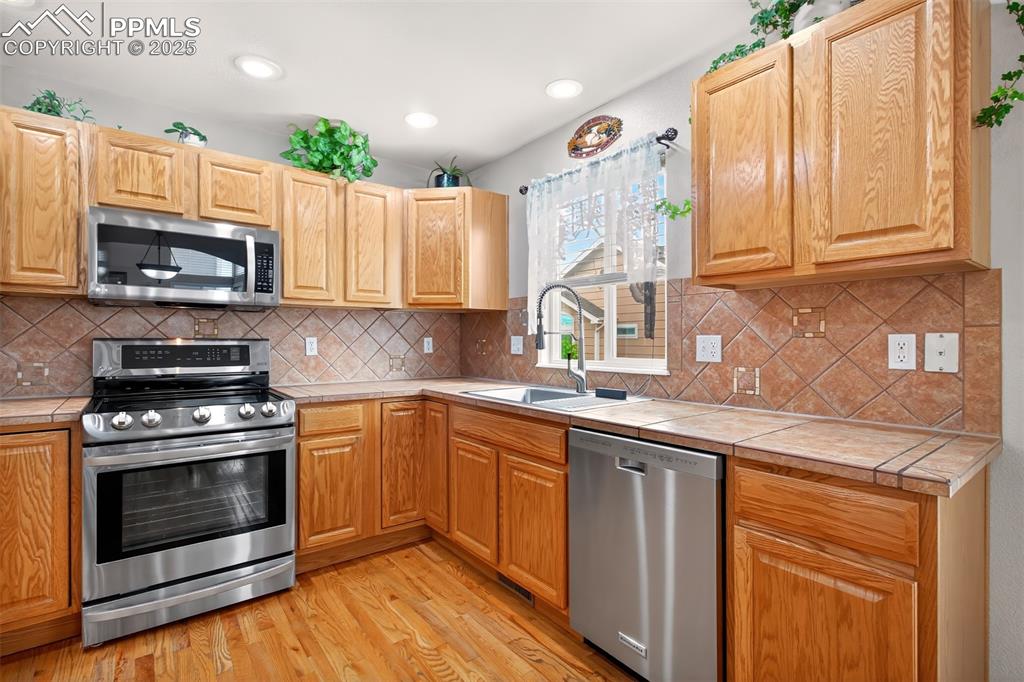 7374 Maybeck View Peyton, CO 80831 - Photo 4 of 38 a kitchen with stainless steel appliances granite countertop a stove a sink dishwasher and a microwave oven with cabinets