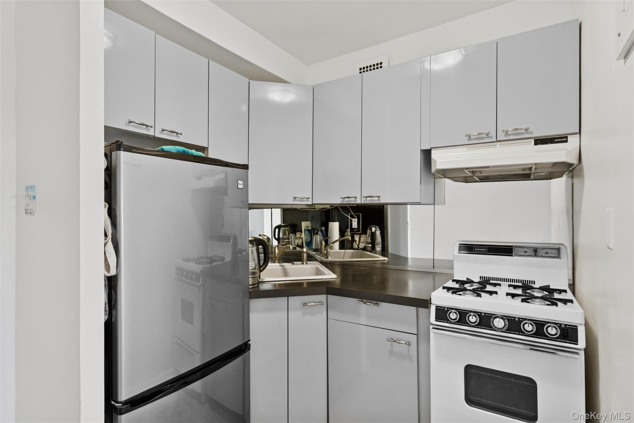 25 Neptune Boulevard, Unit 9S Long Beach, NY 11561 - Photo 8 of 21 a kitchen with a refrigerator and a stove