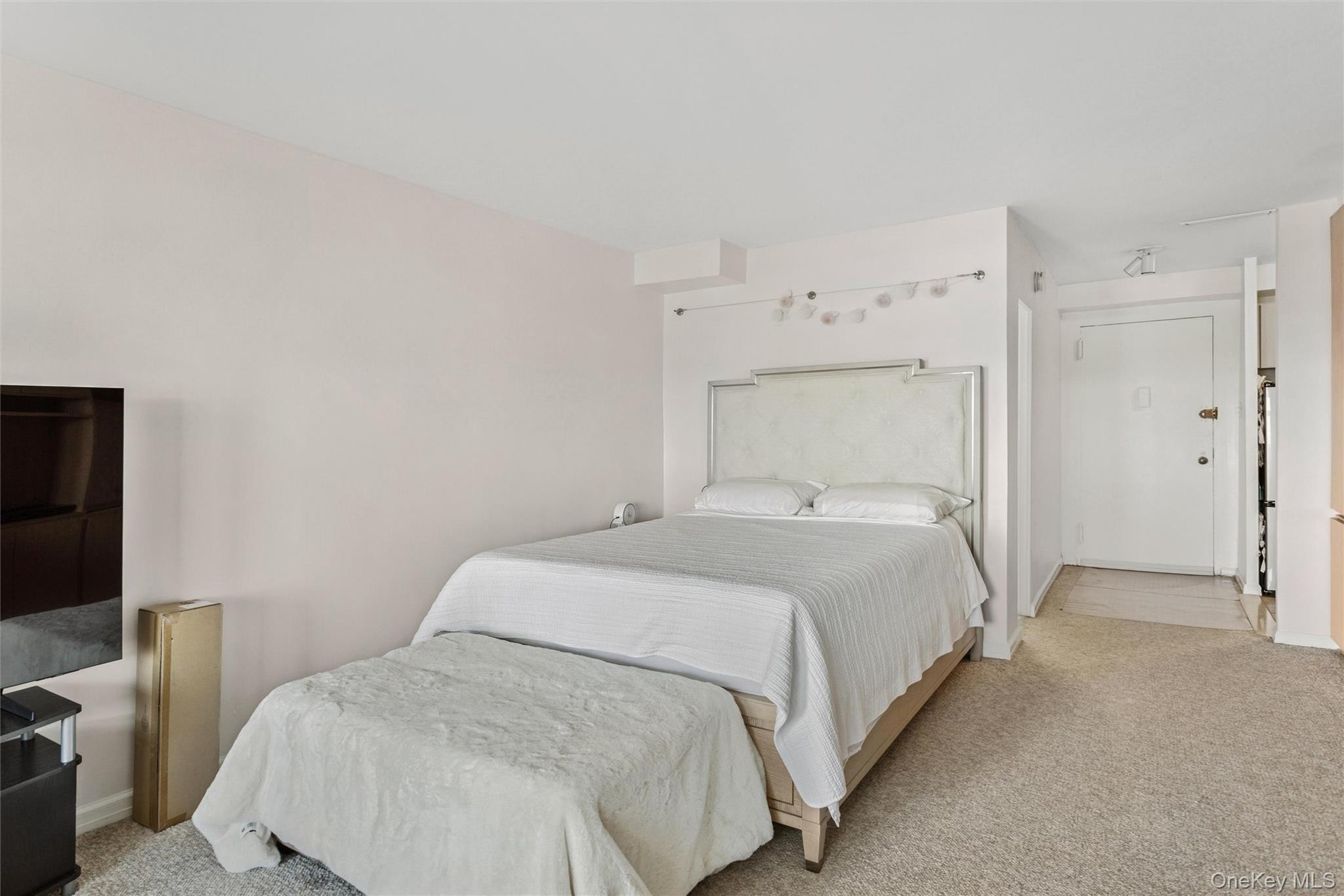 25 Neptune Boulevard, Unit 9S Long Beach, NY 11561 - Photo 10 of 21 a bedroom with a bed and a flat screen tv