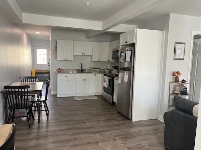 a kitchen with stainless steel appliances granite countertop a refrigerator and a stove top oven