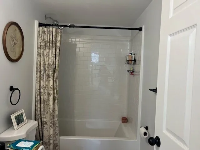 a bathroom with a shower a toilet and a shower