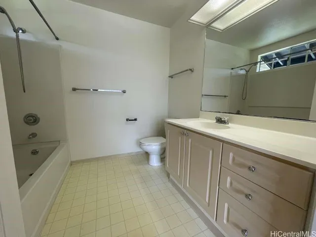 a bathroom with a granite countertop sink a toilet and shower