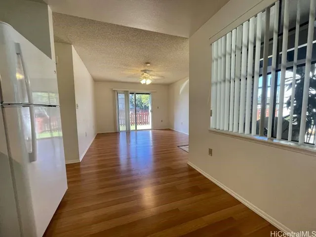 a view of a hallway with wooden floor and windows