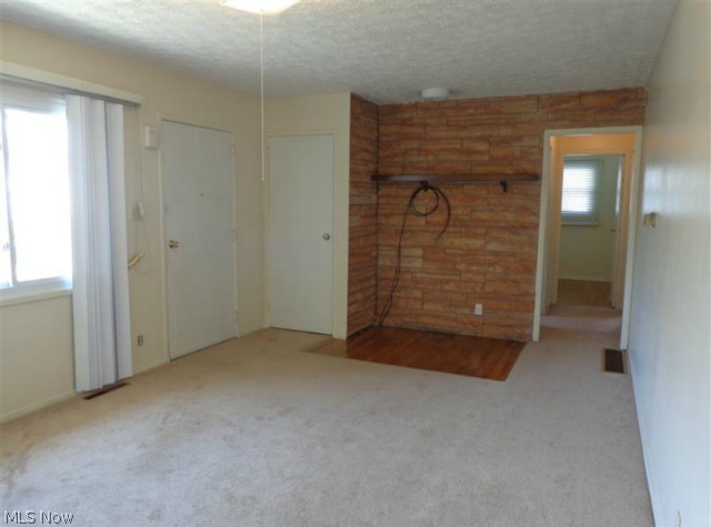 Here we are looking back towards the front door from the entrance to the kitchen.  At one point a wood-burner was in the corner with a vent already in place in case the new owner would like one there again.  Notice the exposed pretty floor.