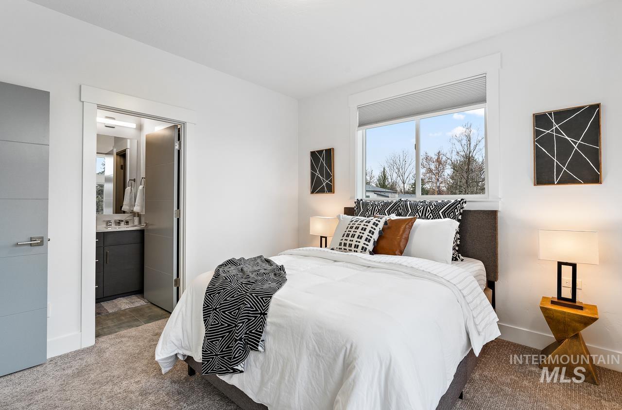 599 West Warren Street Boise, ID 83706 - Photo 40 of 41 Bright bedroom featuring a large window, neutral carpet, and a modern light gray door