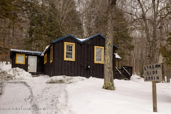 a front view of a house with a yard covered in snow